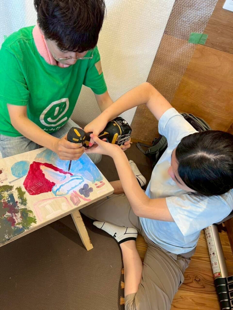 大人と一緒にドライバーでネジ止めしている風景