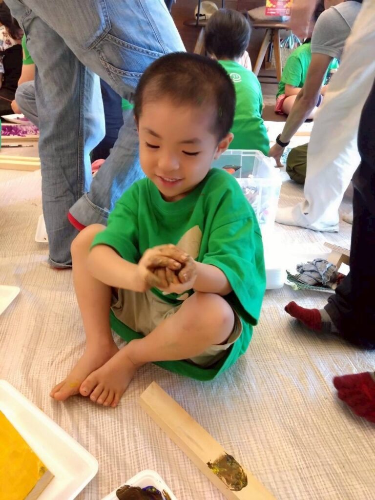 ワークショップの作業で何かを握って楽しんでいる子供の画像